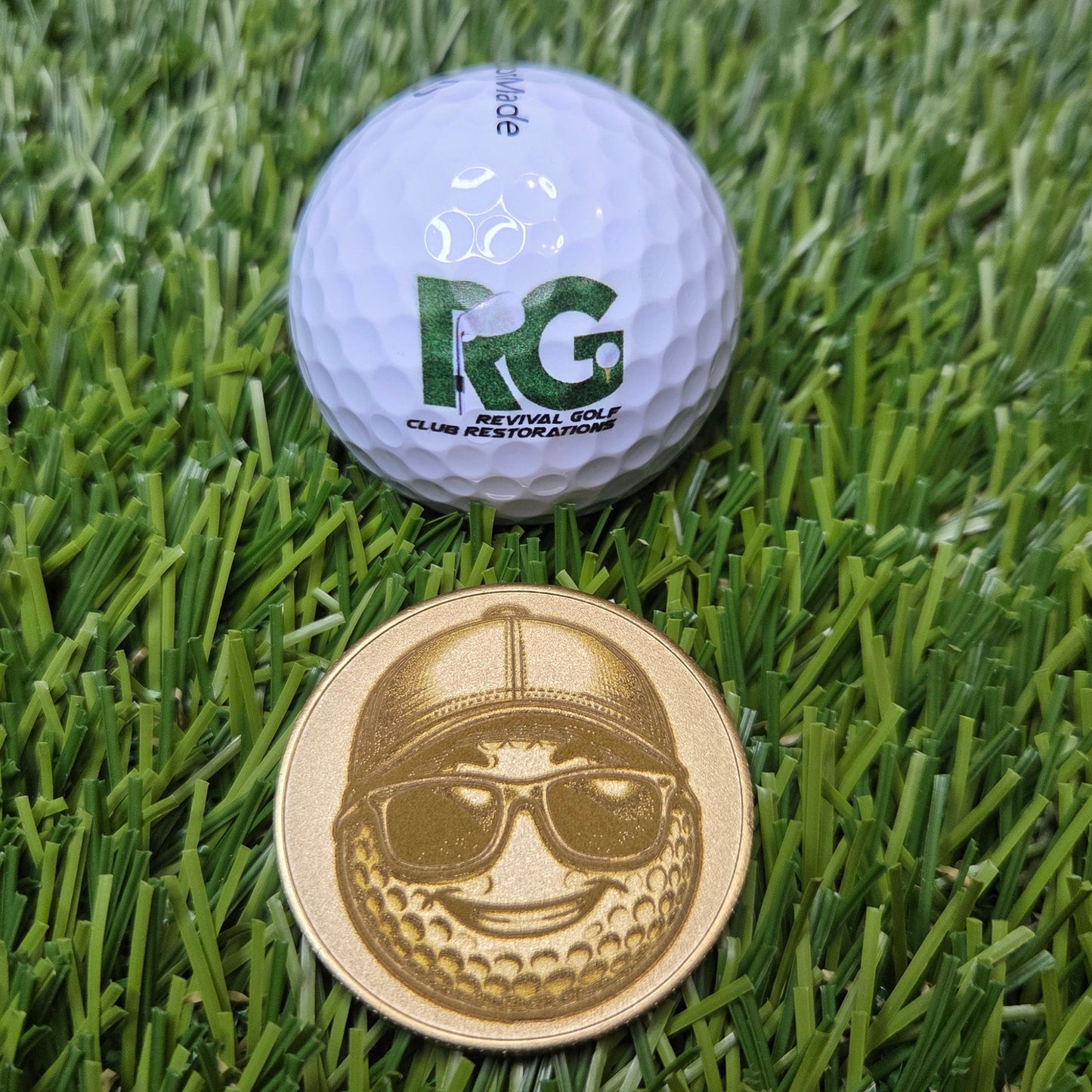 Golf ball and gold coin on green grass