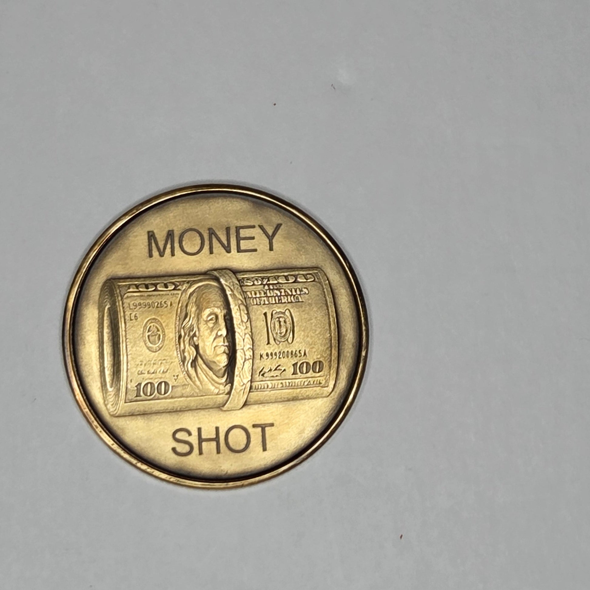 Gold coin with 'Money Shot' text on a gray background