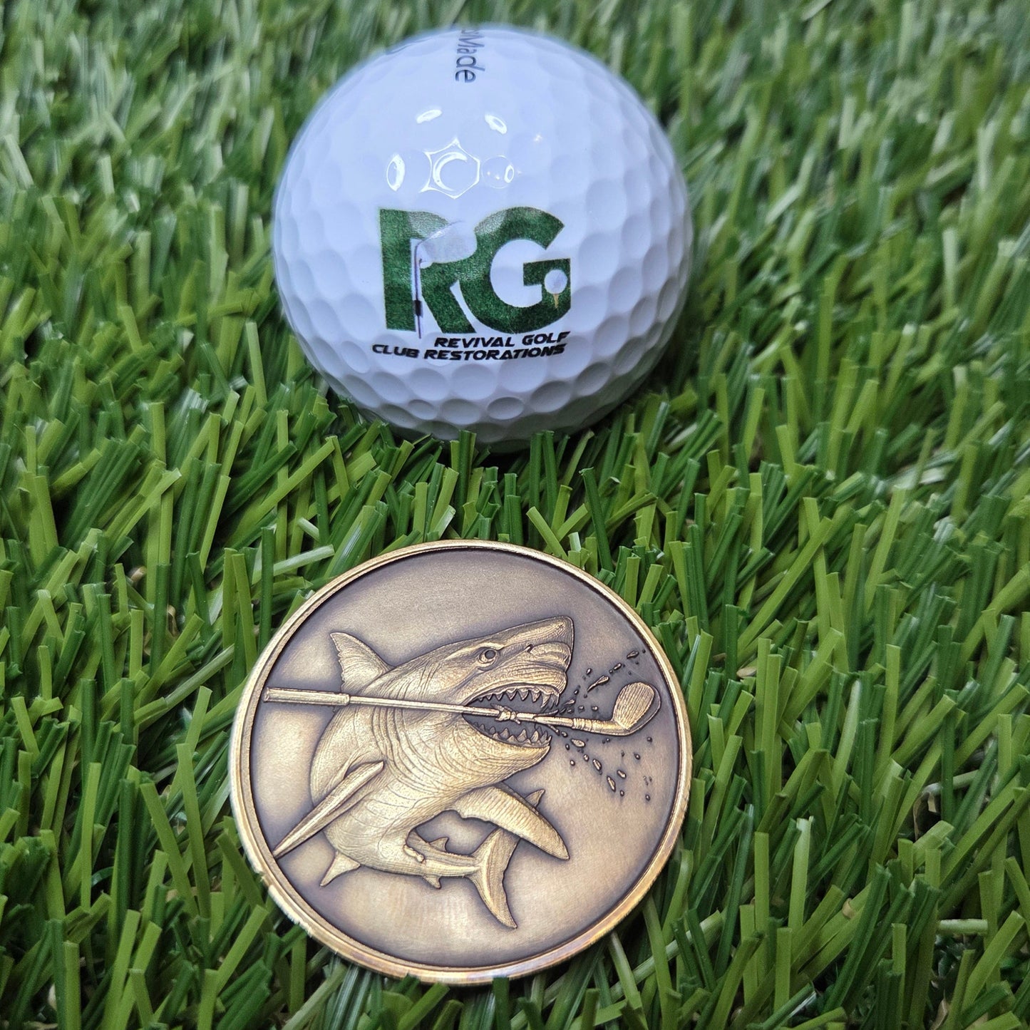 Golf ball and coin on a grass surface