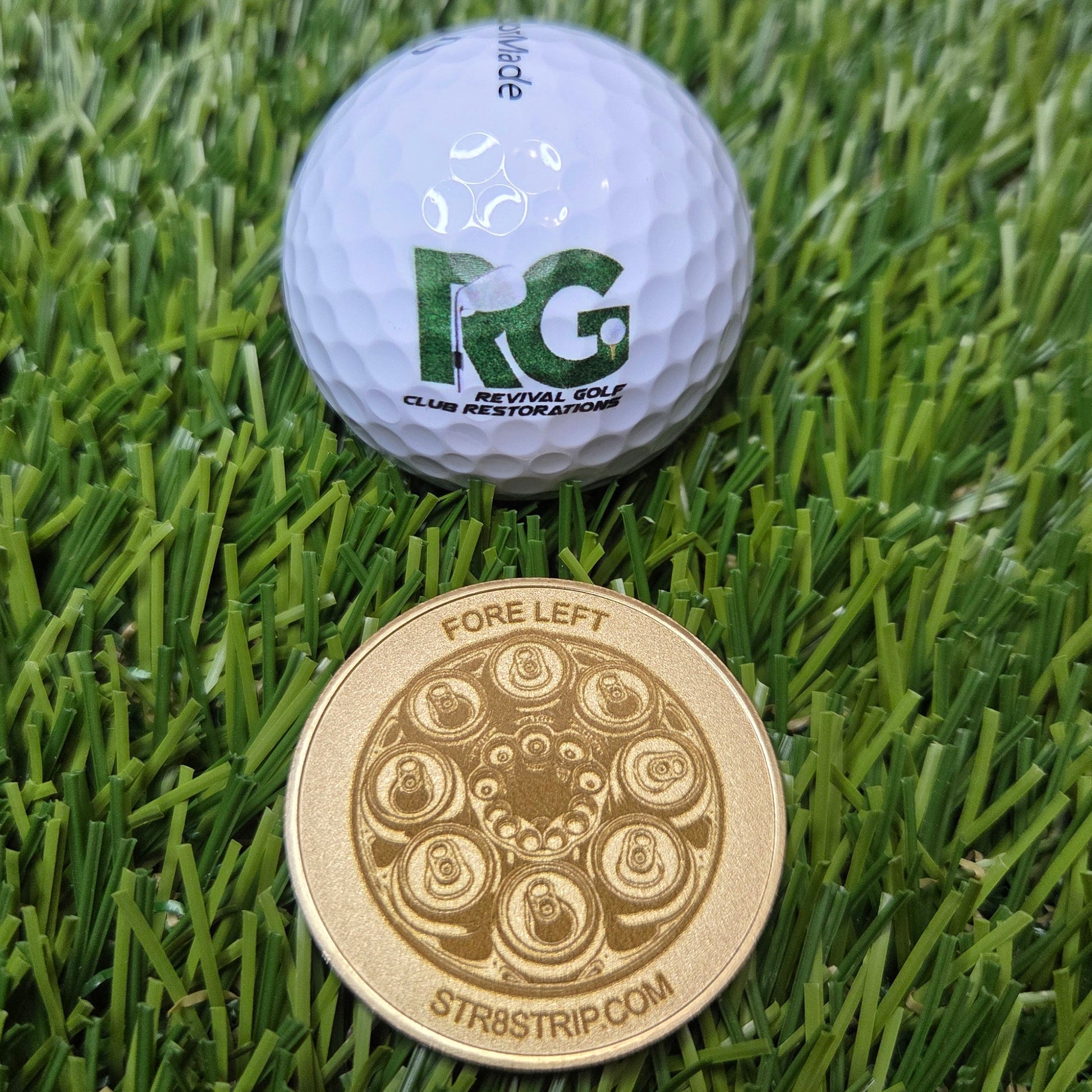 Golf ball and gold coin on grass