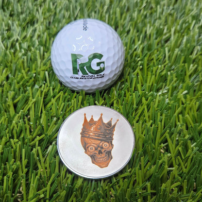 Two golf balls on a grass surface, one with a logo and the other plain.