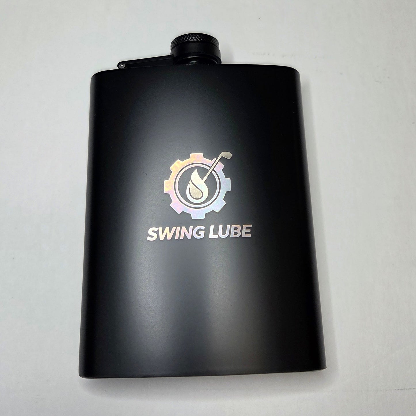 Black bottle of Swing Lube on a light gray background