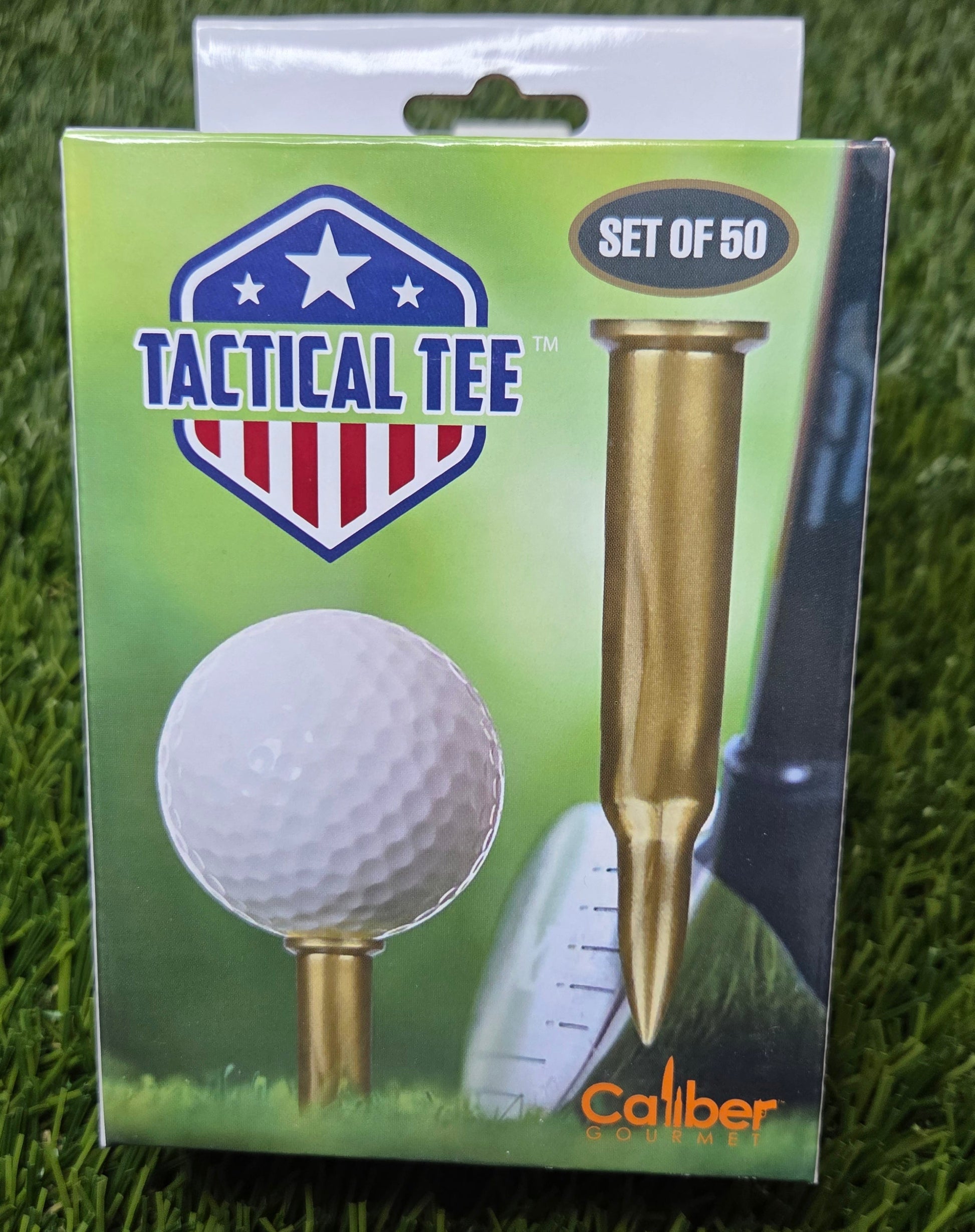 Tactical Tee packaging with a golf ball and tee on a grass background