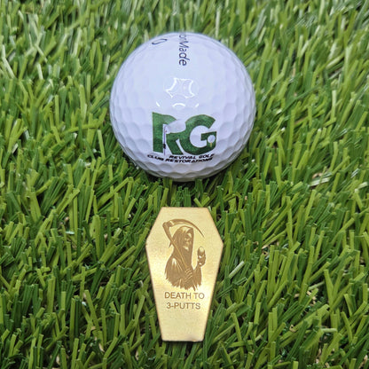 Golf ball and gold marker on green grass