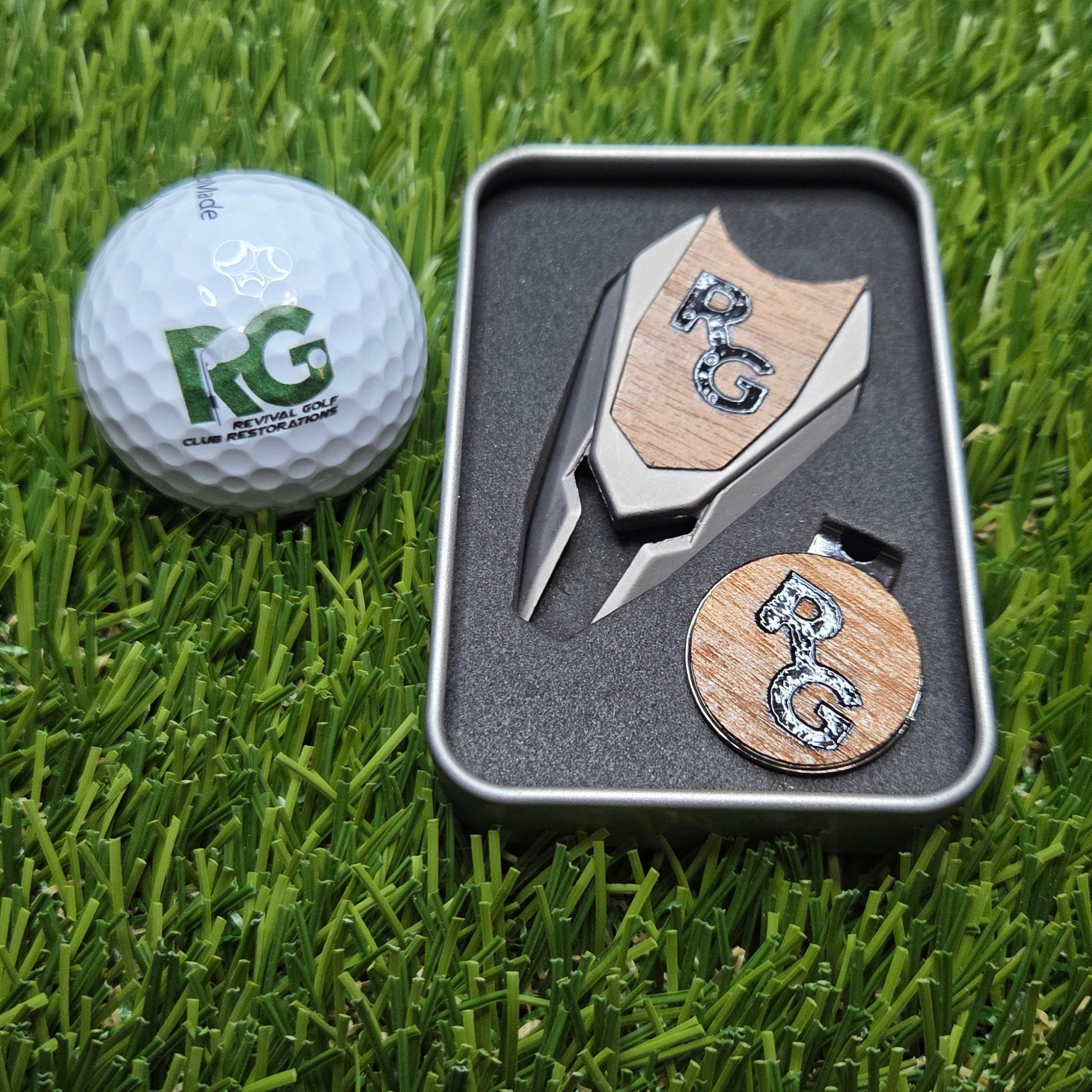 Golf ball with a putter and two wooden markers on grass