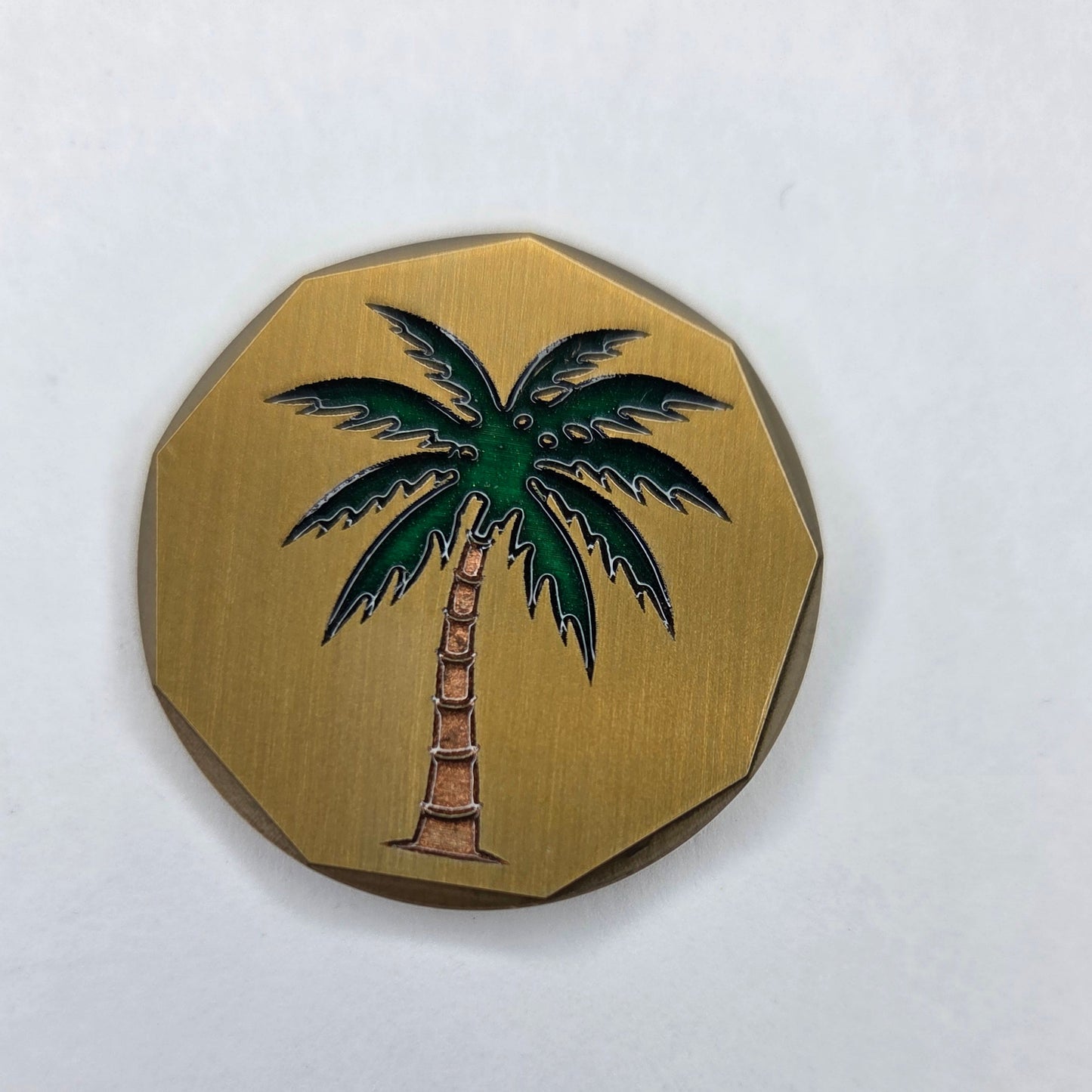 Decorative coin with palm tree design on a white background